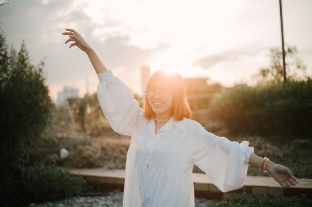 樹木に寄りかかって立っている女性の後ろの景色