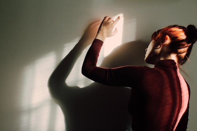 Photo rear view of woman standing against wall at home