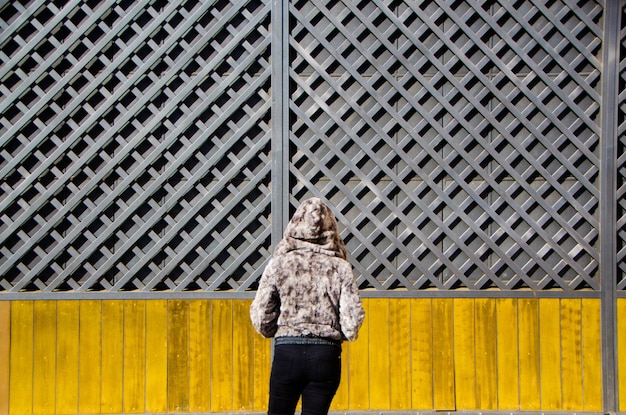 Rear view of woman standing against wall