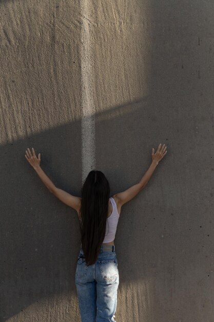 Foto vista posteriore di una donna appoggiata al muro