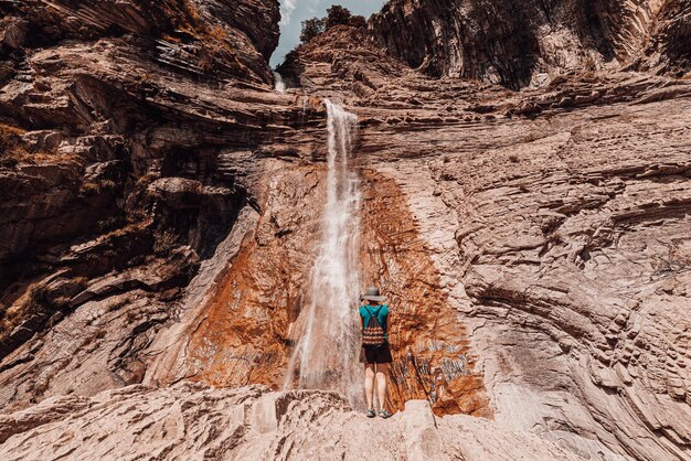 Photo rear view of woman standing against waterfall