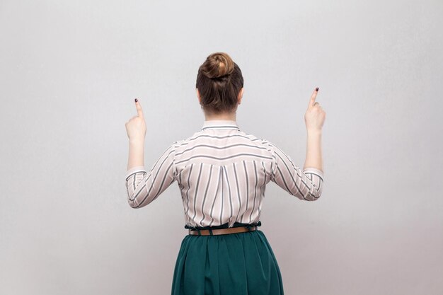 Photo rear view of woman standing against white background