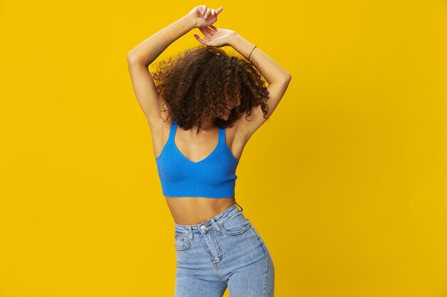 Rear view of woman standing against yellow background