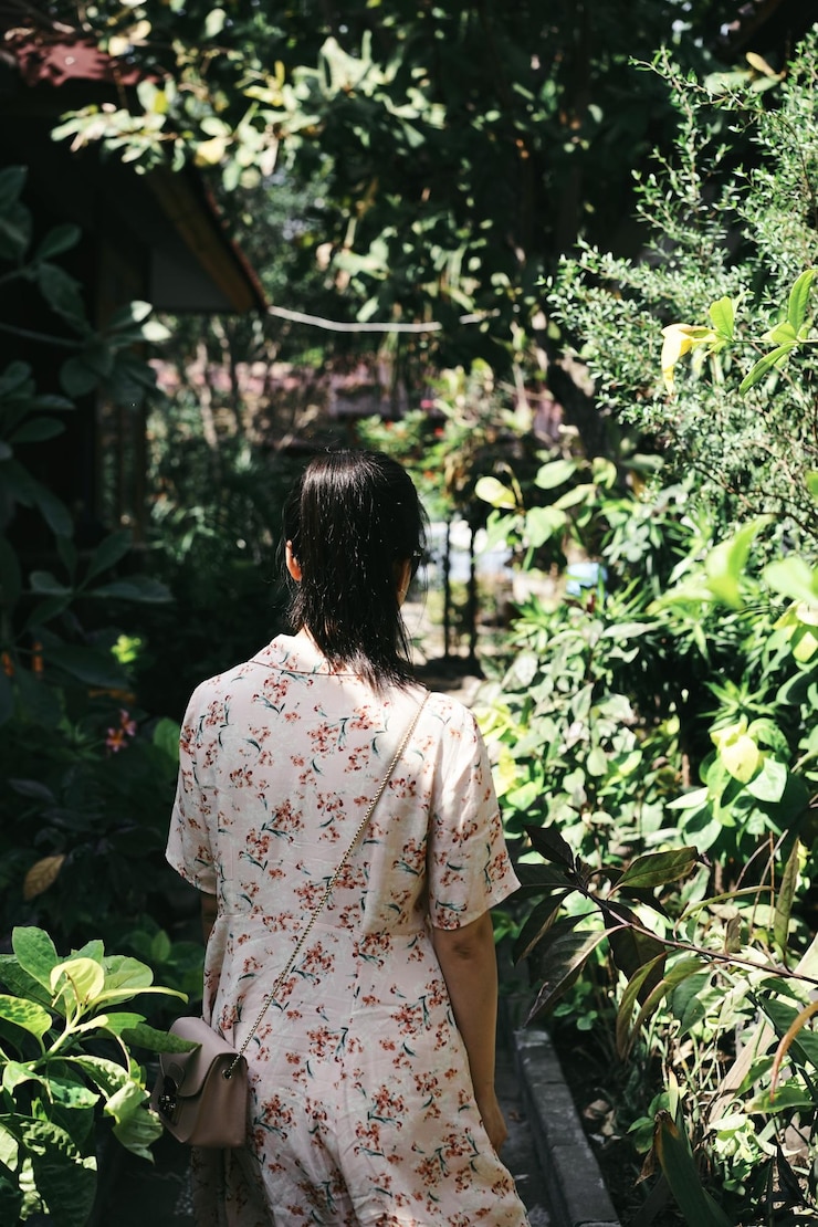 Photo 站在田野上的植物和树木中间的女人