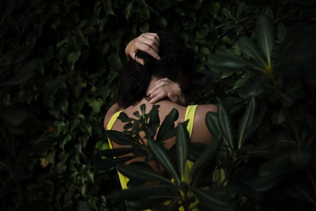 Rear view of woman standing amidst plants