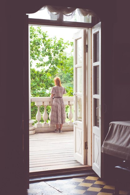 Photo rear view of woman standing in balcony at home