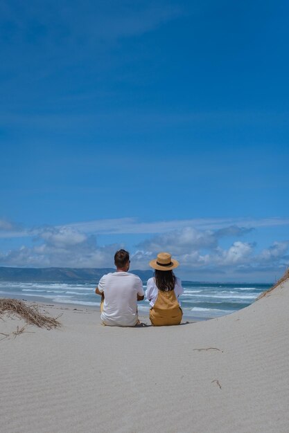 Rear view of woman standing at beach against clear sky