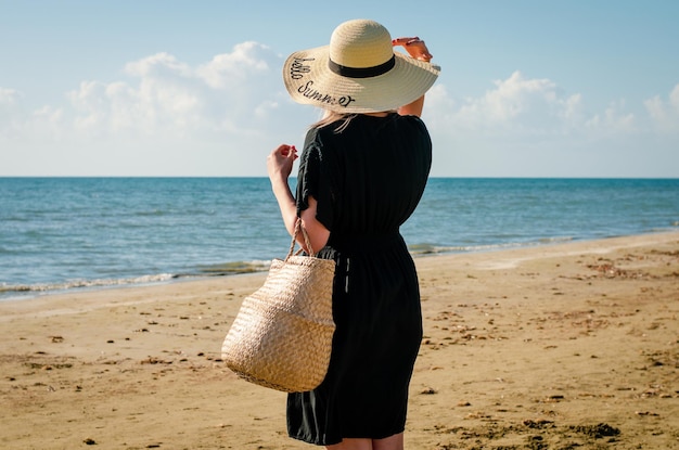 Photo rear view of woman standing at beach against sky