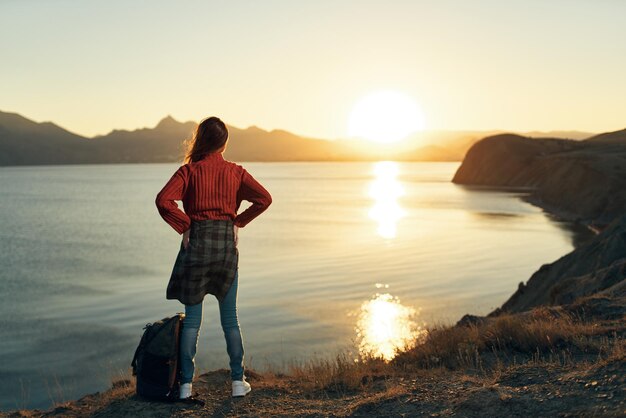 Rear view of woman standing on beach during sunset