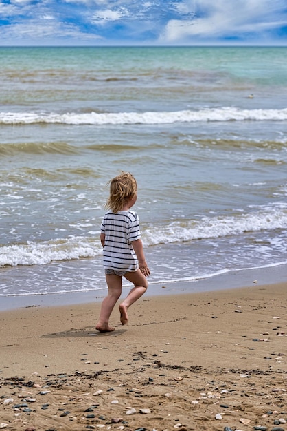 Foto vista posteriore di una donna in piedi sulla spiaggia