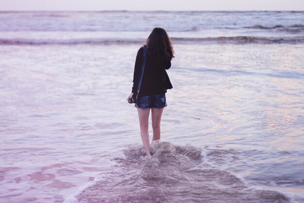 Rear view of woman standing on beach