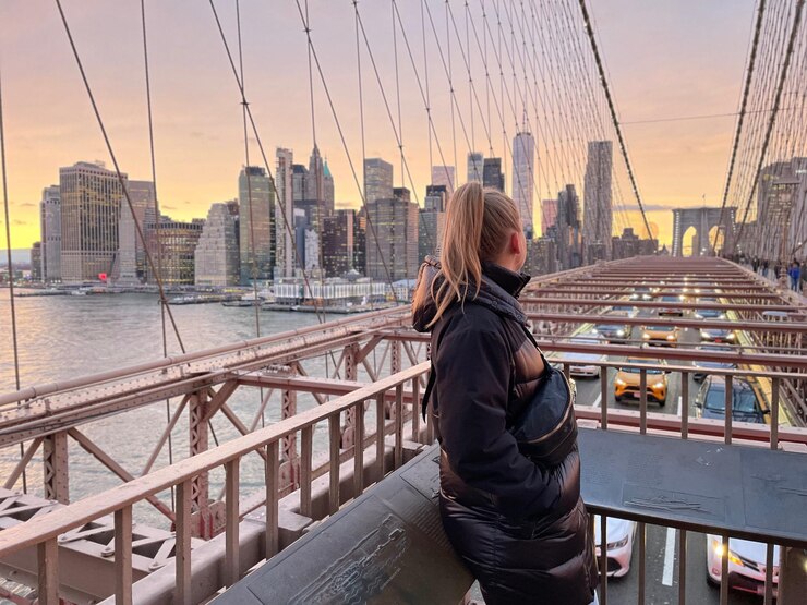 Photo ニューヨークのブルックリンブリッジに立っている女性の後ろの景色
