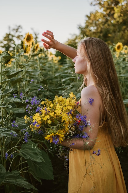 花がく植物のそばに立っている女性の後ろの景色
