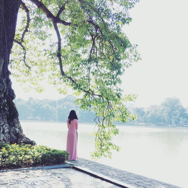 Photo rear view of woman standing by lake