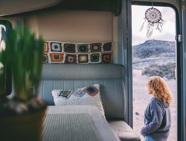 Foto vista posteriore di una donna in piedi vicino al camper