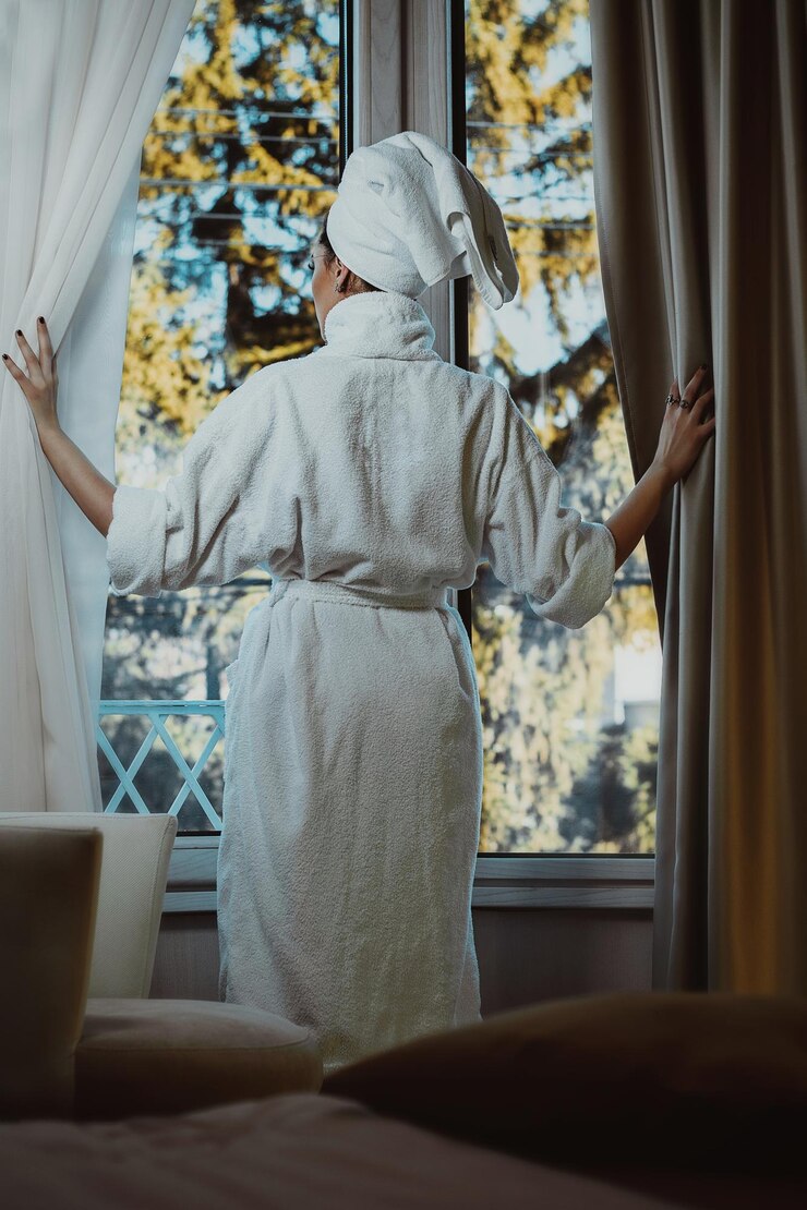 Photo rear view of woman standing by window at home