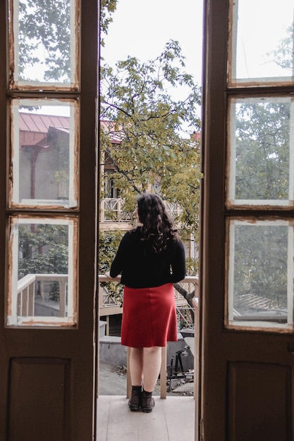 Photo rear view of woman standing by window