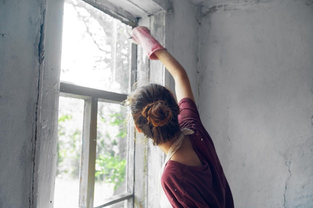 窓のそばに立っている女性の後ろの景色