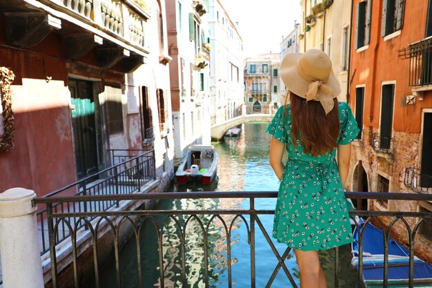 Foto vista posteriore di una donna in piedi sul canale dalla ringhiera in città