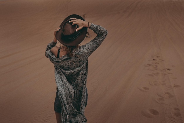 Foto vista posteriore di una donna in piedi nel deserto