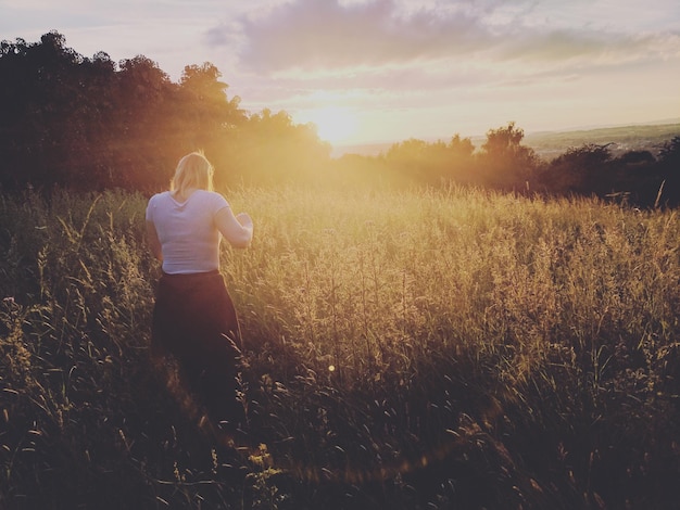 Photo rear view of woman standing on field against sky