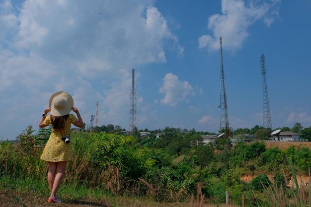 Rear view of woman standing on field against sky