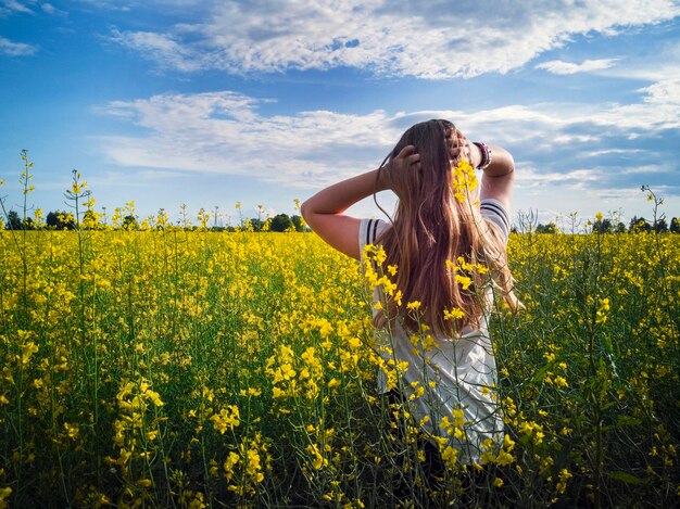 Photo rear view of woman standing on field against sky