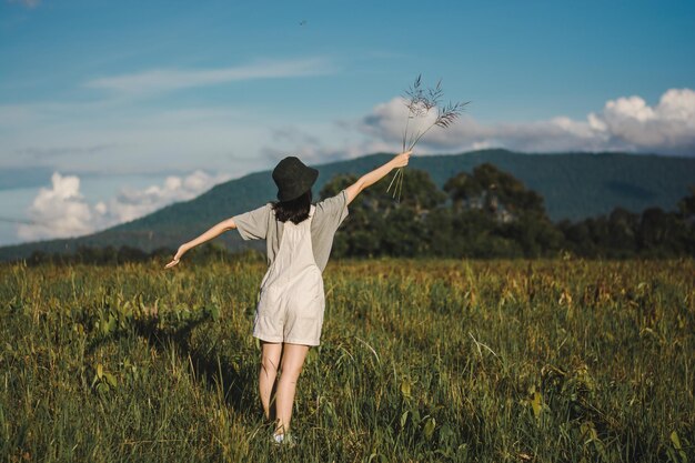 Photo rear view of woman standing on field against sky