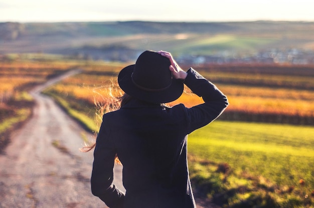 Photo rear view of woman standing on footpath