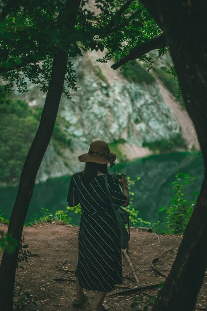 Foto vista posteriore di una donna in piedi nella foresta