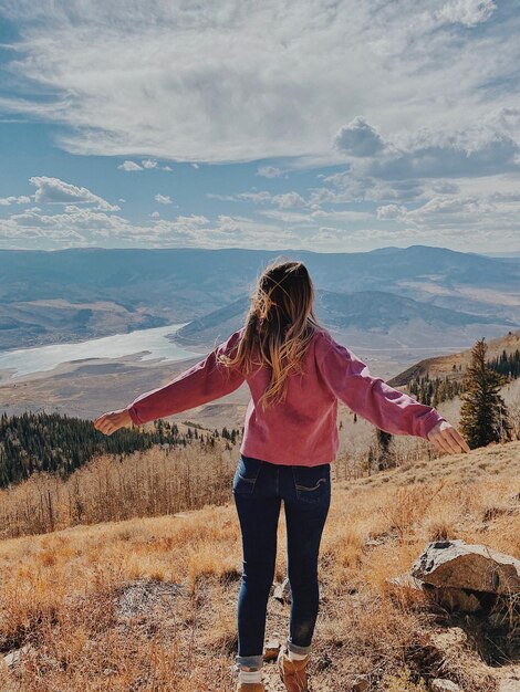 Rear view of woman standing on land against sky