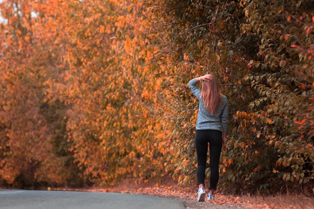 Rear view of woman standing on land during autumn