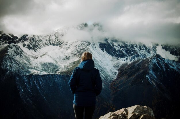 Photo rear view of woman standing on mountain against sky