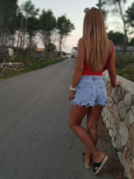 Photo rear view of woman standing on road