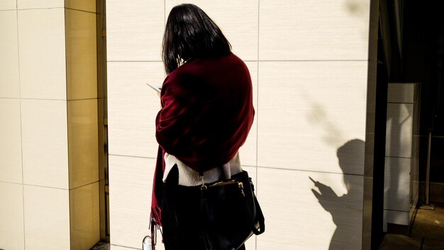 Foto vista posteriore della donna in piedi e dell'ombra