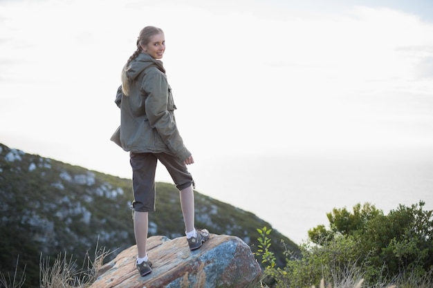 Rear view of woman standing on stone looking back