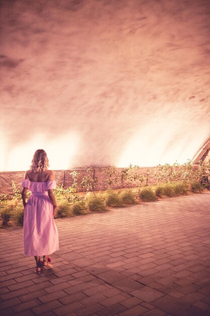 Foto vista posteriore di una donna in piedi per strada di notte