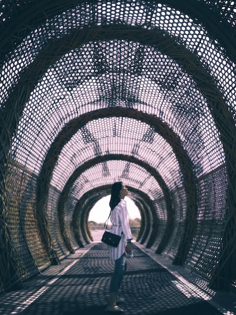 Foto vista posteriore di una donna in piedi nel tunnel