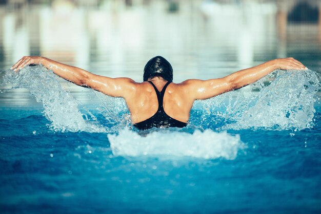 Rear view of woman swimming in pool