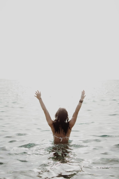 Photo rear view of woman swimming in sea against clear sky