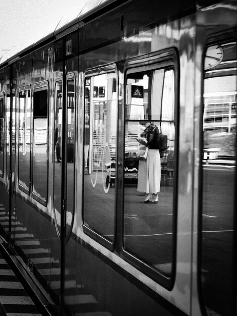 鉄道駅の電車に乗っている女性の後ろの景色