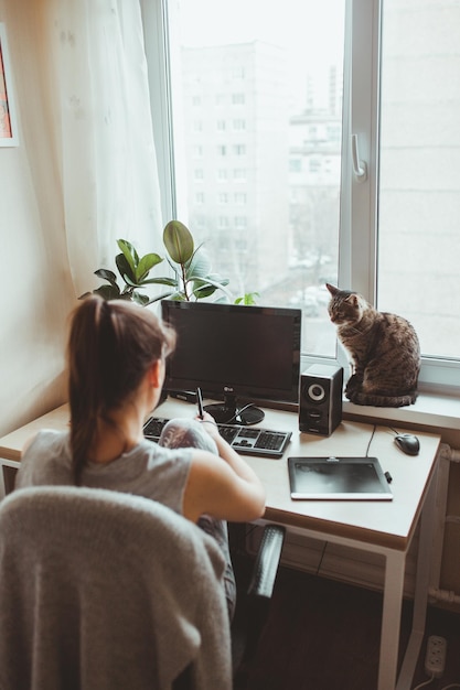 デスクトップPCを使用する女性の後ろの景色