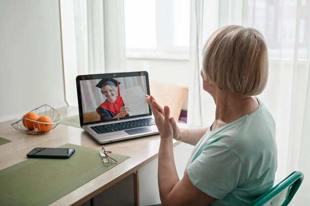 Rear view of woman using laptop on table