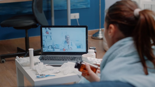 Photo rear view of woman using laptop on table