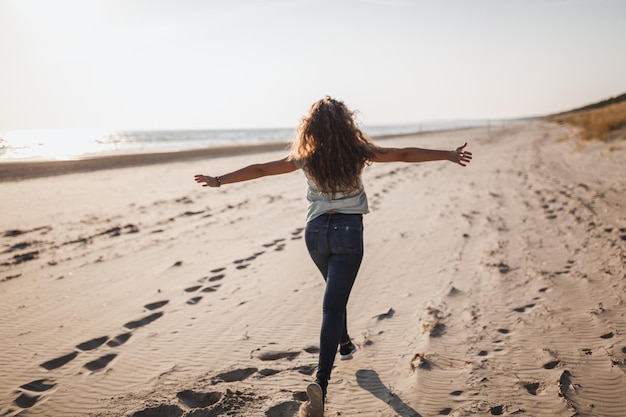 Rear view of woman walking on beach