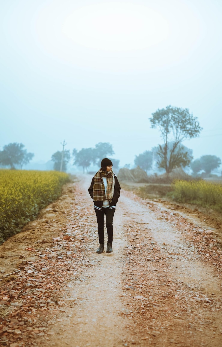 फोटो कच्ची सड़क पर चलती महिला का पीछे का दृश्य