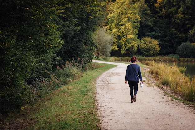 Photo rear view of woman walking on dirt road