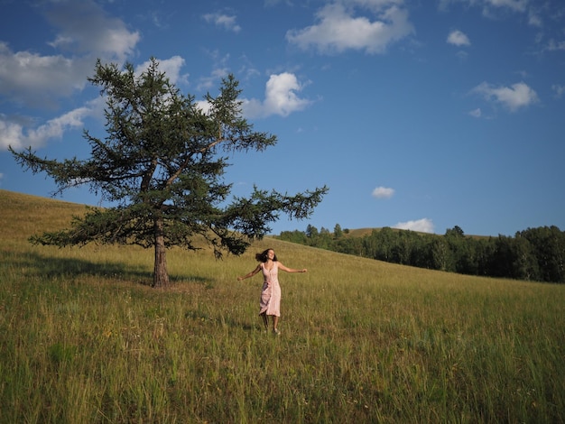 Rear view of woman walking on field against sky