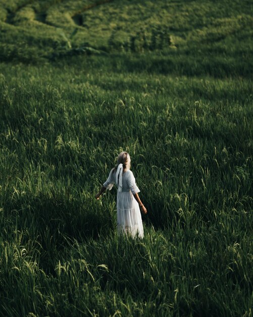 Photo rear view of woman walking on field