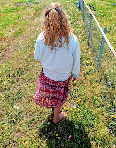 Photo rear view of woman walking on field